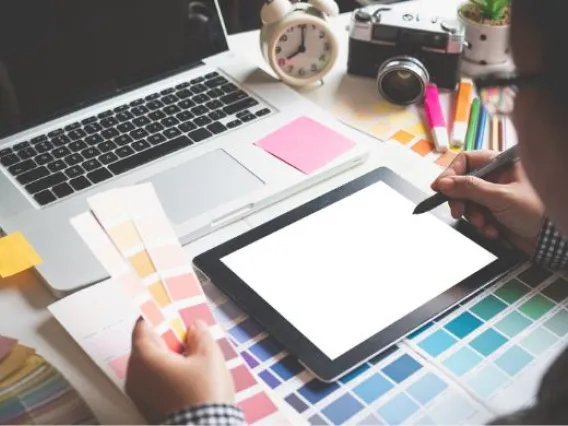 laptop, color swatches, and a person holding a tablet