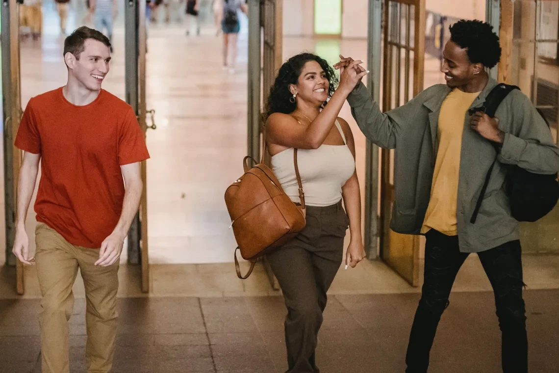 3 students walking in a class hallway